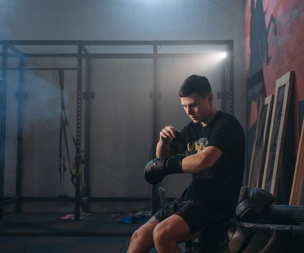 Silhouette of a man stretching against a sunrise, symbolizing energy.